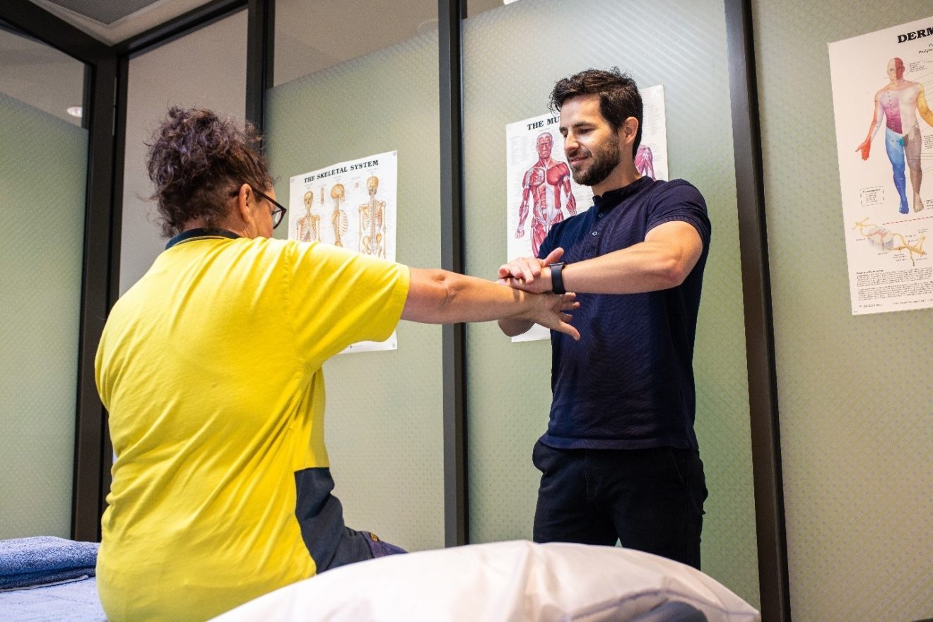 A photograph of SMCT Osteopath Tom Peasley assessing a client