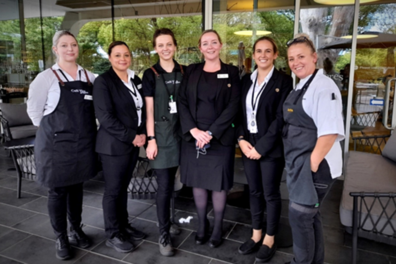Our hospitality team smiling outside Café Vita et flores, Springvale Botanical Cemetery.