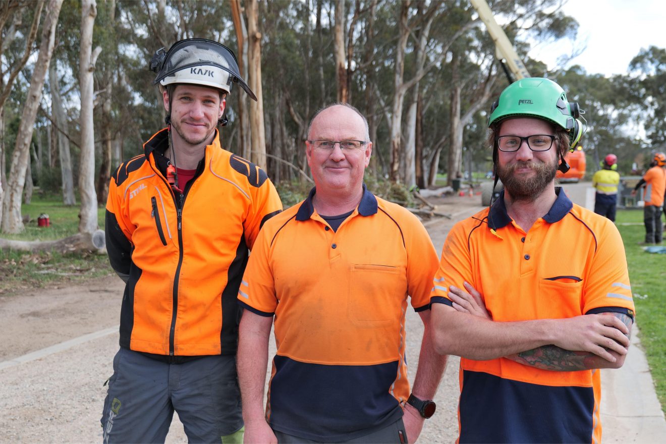 Three men wearing high-vis shirts.