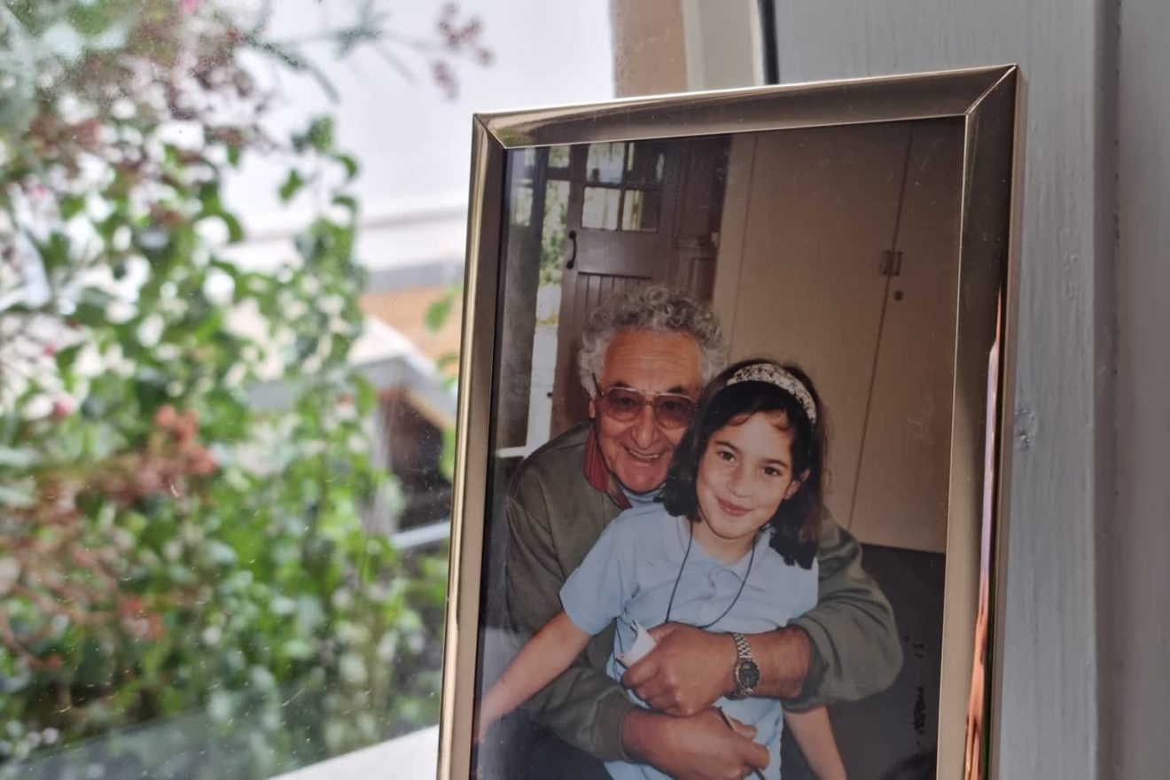 A photograph of Marek and Leah Mandeltort, framed and resting on a windowsill