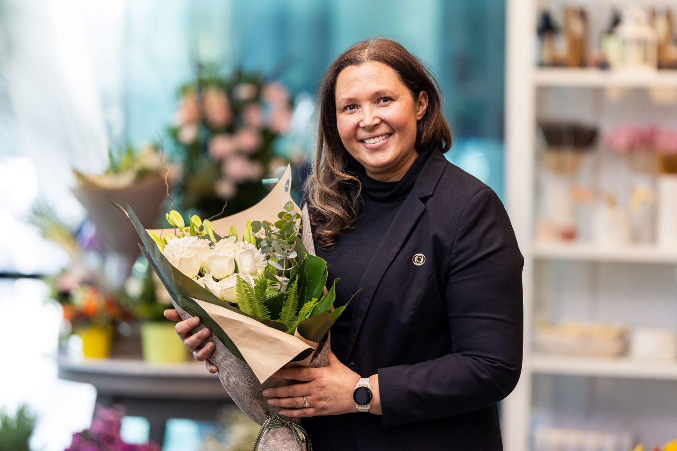 Florist woman with brown hair holding a bouquet of beautiful flowers at the florist shop at Springvale Botanical Cemetery.
